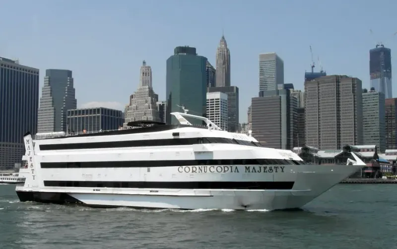 Cornucopia Majesty party cruise yacht on the water in front of the Lower Manhattan skyline