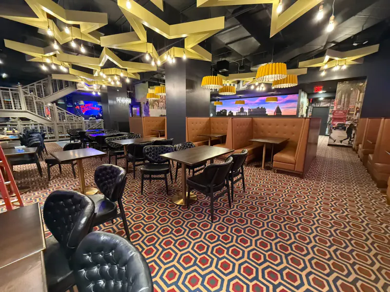 Dining room at Planet Hollywood Times Square with leather booths, patterned carpet and gold star ceiling lights