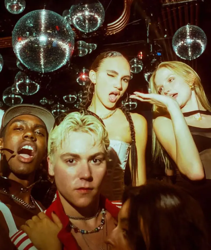 Group of friends posing and making faces under a cluster of disco balls at Loosies Nightclub in NYC